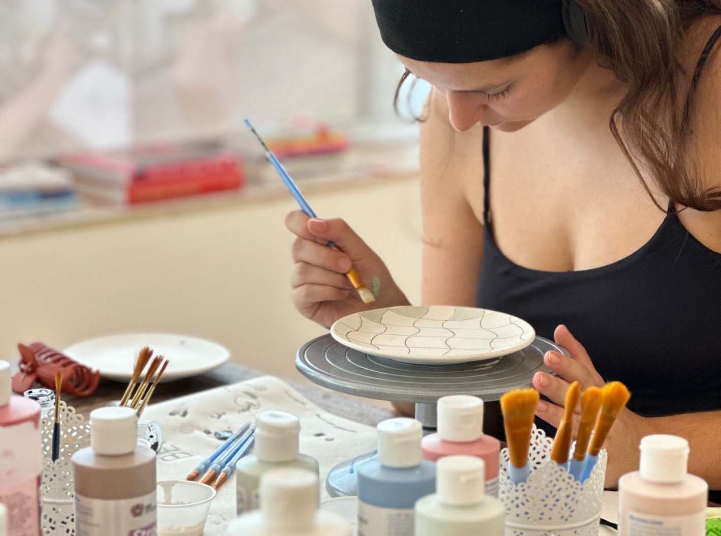 Família multigeracional a pintar cerâmica junta no estúdio